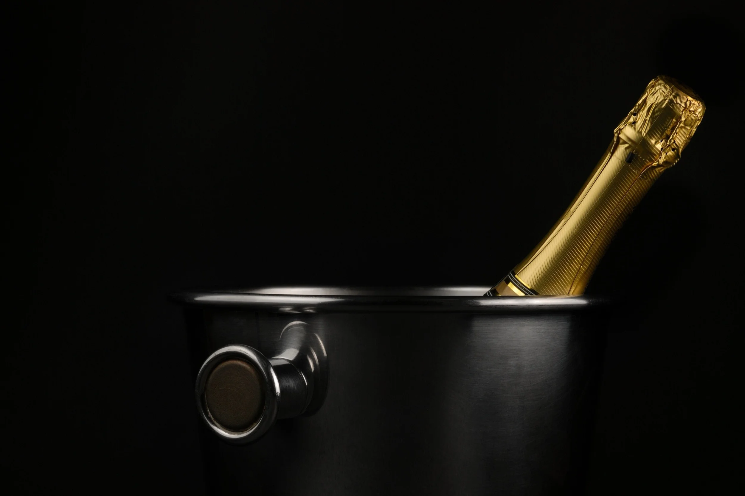 Eine Flasche in einem Kühler vor dunklem Hintergrund.